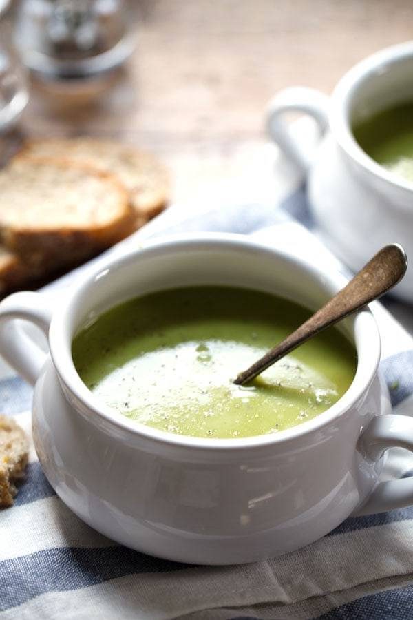 Creamy Potato Kale Soup in a white bowl with a spoon.