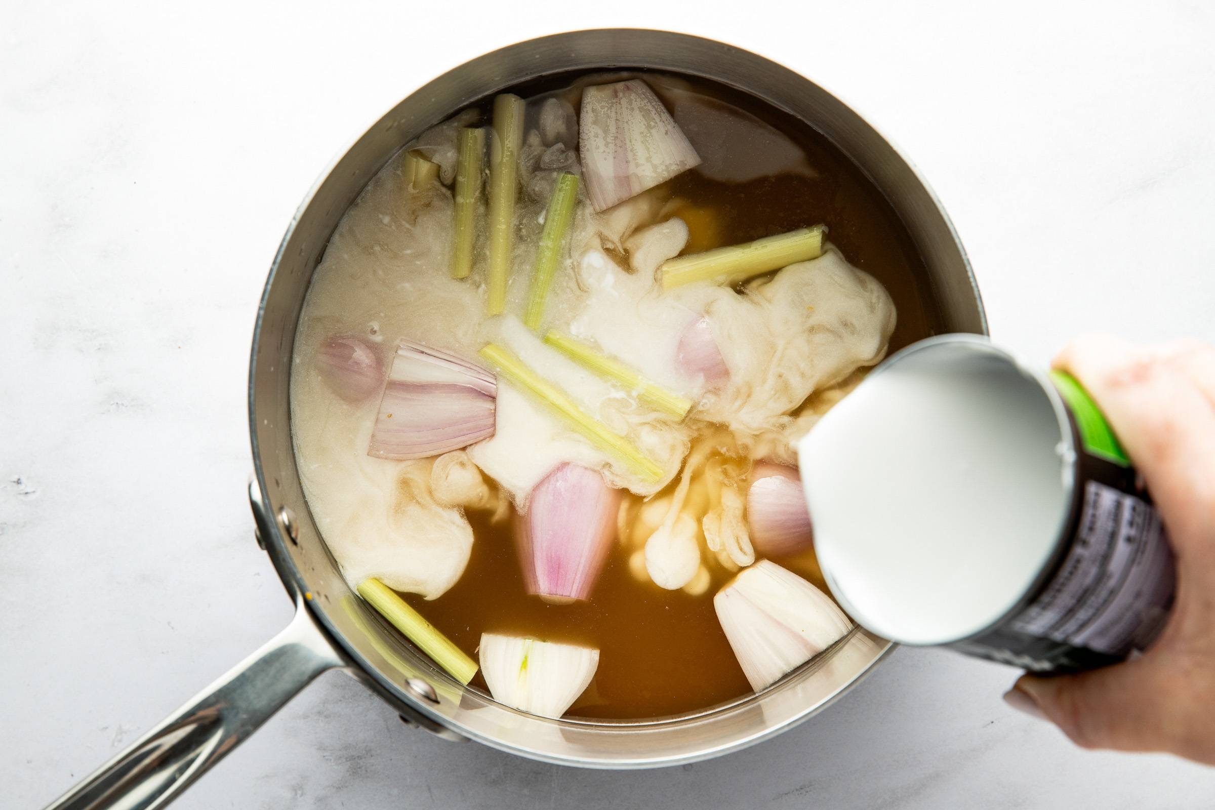 Adding ingredients to pot for broth.