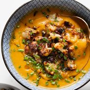 Sweet potato soup in a bowl topped with cauliflower crumbles.