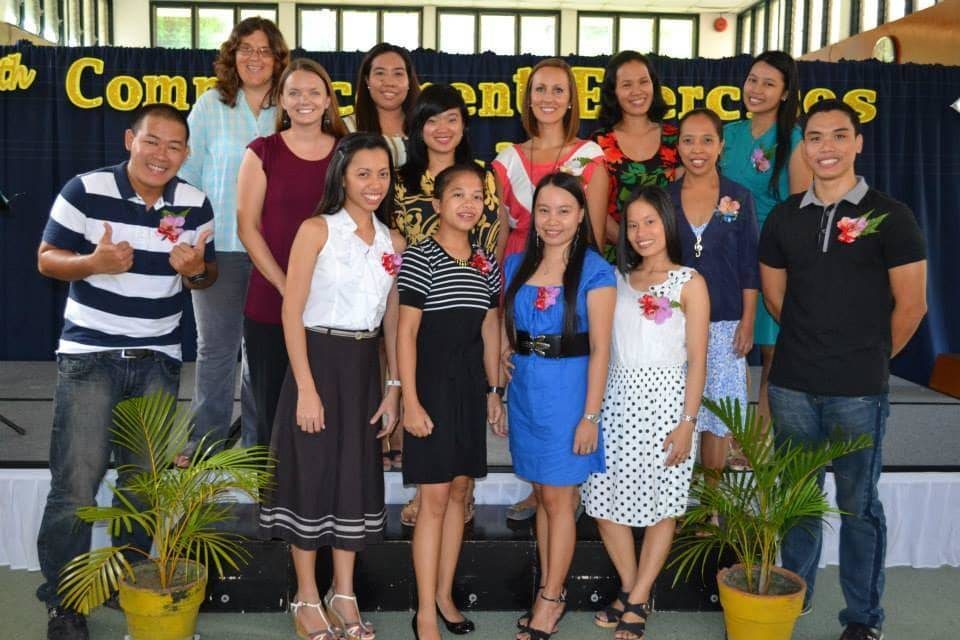 Group of people standing and smiling.